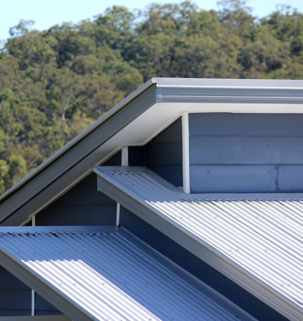 A blue roof with two white roofs above, showcasing the Gutter Cleaning Guys' services for your home.